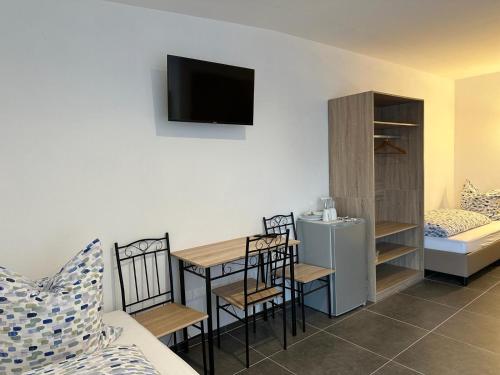 a small room with a table and chairs and a bedroom at Pension Boardinghaus Dingolfing in Dingolfing