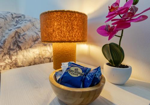 Un bol de patatas fritas sobre una mesa con una lámpara y una planta. en Urban Guest House Livorno "Port Area", en Livorno