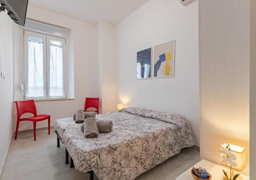 Un dormitorio con una cama y dos sillas rojas. en Urban Guest House Livorno "Port Area", en Livorno