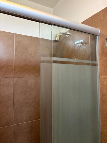 a glass shower with a faucet in a bathroom at Departamento Liban in San Juan