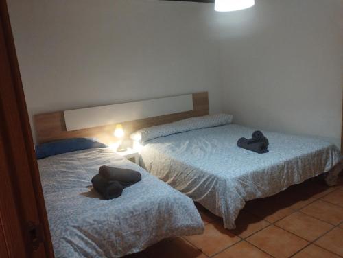 2 Betten mit Hüten auf einem Zimmer in der Unterkunft Calatorao apartamentos in Calatorao