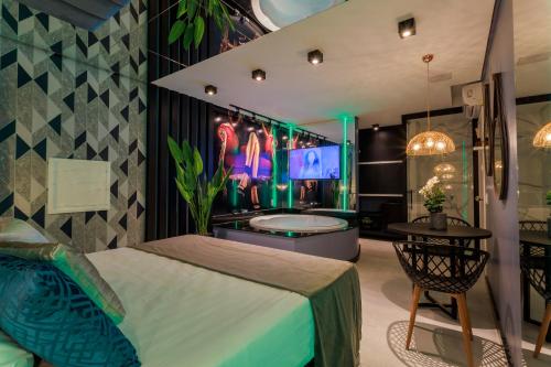 een slaapkamer met een bad, een bed en een tafel bij Motel Hotel Paradiso - Ibirubá-RS in Ibirubá