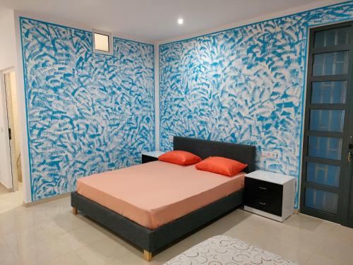 a bedroom with a bed and a blue wall at Residencial Oliveira in Porto Novo