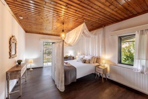 a bedroom with a large bed and a wooden ceiling at Maison du Mont in Kalopanayiotis