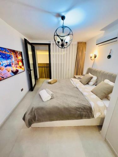 a bedroom with a large bed and a chandelier at 3 bedrooms villa with own pool! in Pano Dheftera