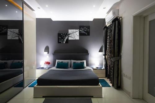 una camera da letto con un letto grande con cuscini blu di Modern, stylish & comfortable 3 bedroom apartment with jacuzzi, aquarium and private yard with barbeque a Mellieħa