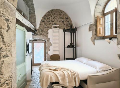 una camera da letto con un letto e un muro di pietra di Molinu a Santu Lussurgiu
