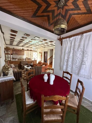 a dining room with a red table and chairs at Kokkotis Residence in Samarina