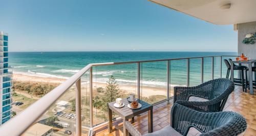a balcony with two chairs and the ocean at Talisman Beachside Broadbeach in Gold Coast