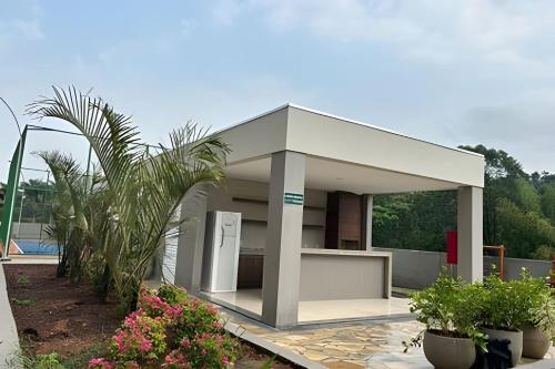 a small house with a refrigerator in a garden at Grace Prime Loft - aconchego em Extrema MG in Extrema