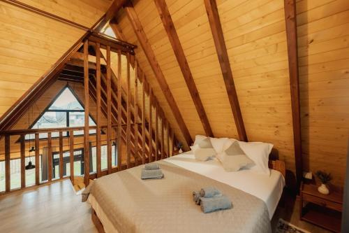 una camera da letto con un letto in una cabina di legno di Cabana AFrame EmAli a Poiana Teiului