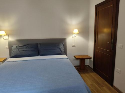 a bedroom with a blue bed and a wooden table at La casetta di San Filippo in Bagni San Filippo