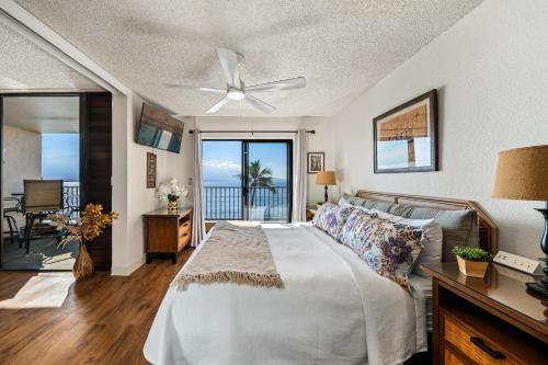 a bedroom with a bed and a view of the ocean at Lauloa 303 in Wailuku