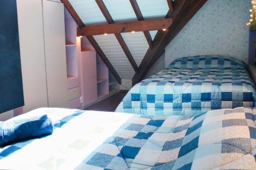 a bedroom with a bed with blue and white checkered sheets at GramadoPenthouse 4quartos 3banheiros in Gramado