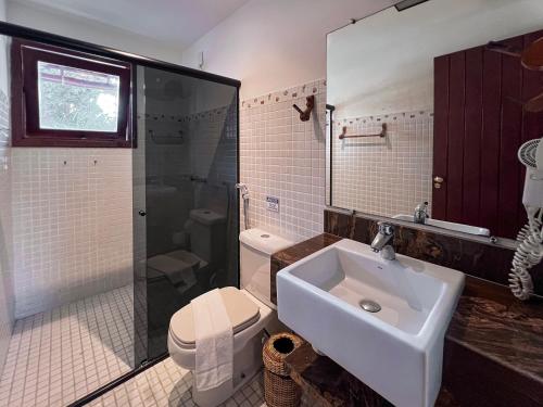 a bathroom with a sink and a toilet and a shower at Pousada Arraial Candeia in Arraial d'Ajuda