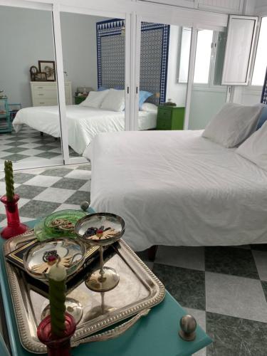 a bedroom with two beds and a tray with food on it at Casa Michel in Chipiona
