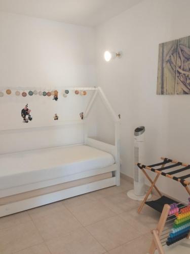 a white room with a bed and a chair at Golden Refúgio das Andorinhas in Cabanas de Tavira