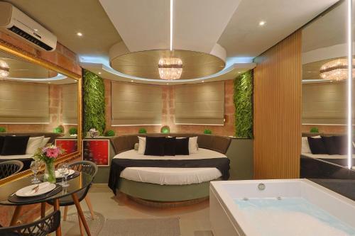 a bedroom with a bed and a tub in a room at Hotel Motel Paradiso - Panambi-RS in Tabapira