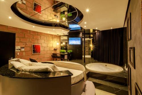 een badkamer met een bad en een wastafel en een ligbad bij Hotel Motel Paradiso - Panambi-RS in Tabapira