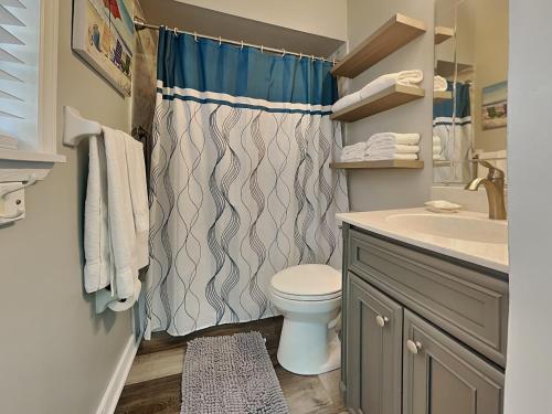 a bathroom with a toilet and a shower curtain at Sunset Beach House in Pittman Center