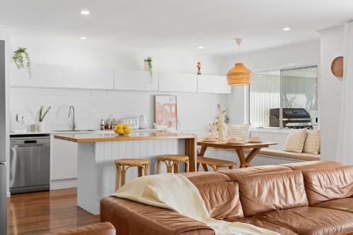 a living room and kitchen with a couch and a table at Palm Cove Retreat - Walk to beach & CBD in Maroochydore