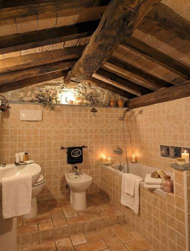 a bathroom with a toilet and a sink and a tub at Mulino del Lentino in Nibbiano