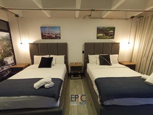 two beds in a hotel room with two bedsitures at Epic Suite 312 Deluxe Airport in Cuba