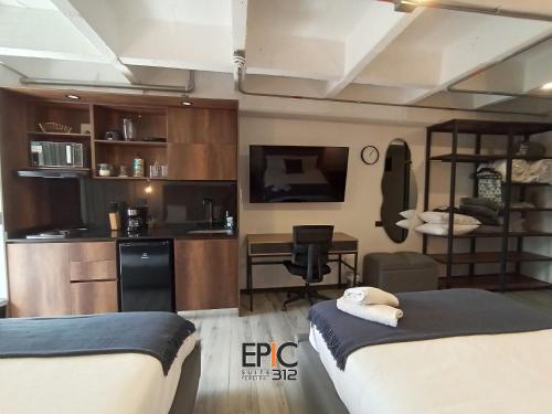 a room with two beds and a kitchen with a desk at Epic Suite 312 Deluxe Airport in Cuba