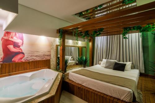 a bedroom with a bed and a bath tub at Florence Motel Spa - Santa Rosa-RS in Santa Rosa