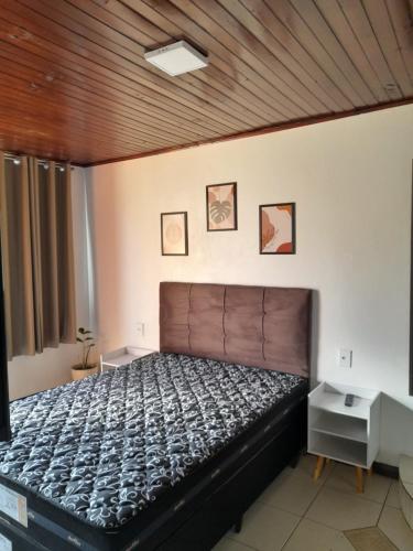 Un dormitorio con una cama y un techo de madera. en Kitnet Praia do Porto, en Imbituba