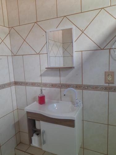 un baño con lavabo y espejo en Kitnet Praia do Porto, en Imbituba