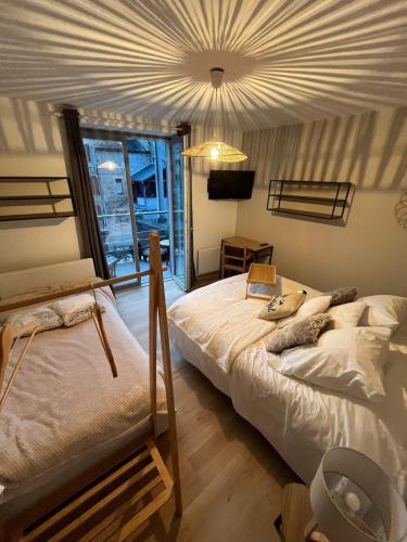 a bedroom with a large bed and a chandelier at Gite du Lac Pavin in Besse-et-Saint-Anastaise