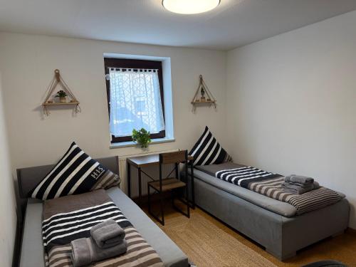 ARCOS Apartment - Geräumige 3-Zimmer-Wohnung mit 8 Einzelbetten - Perfekt für Familien, Gruppen oder Monteure في كابل غرافنهاوسن: غرفة معيشة بها سريرين ونافذة