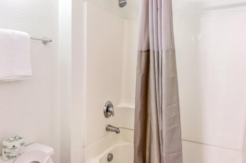 a bathroom with a shower curtain and a toilet at Motel 6-Bakersfield, CA - East in Bakersfield