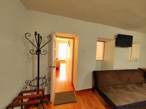 库斯科Centro Cusco Inti的带沙发和电视的客厅以及走廊