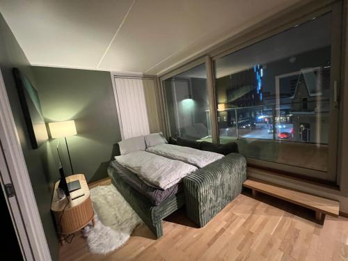 a bedroom with a bed and a large window at Tromsø Central Stay in Tromsø