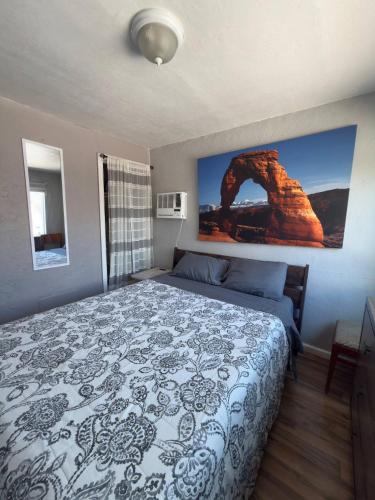 a bedroom with a large bed with a picture on the wall at Cute Bungalow 1 Mile from U of A in Tucson