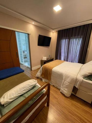 a hotel room with a bed and a window at Quarto-Suíte Serra Petrópolis in Petrópolis