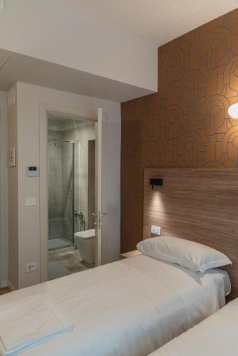 a bedroom with a bed and a bathroom with a tub at Hotel Del Sole in Milan