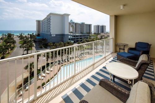 uma varanda com cadeiras e uma mesa e vista para o oceano em Ariel Dunes I 507 Beach side resort em Destin