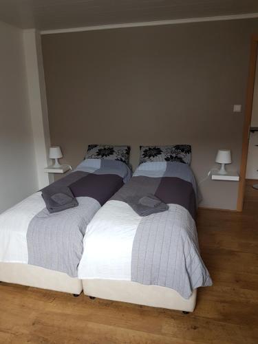 two beds sitting next to each other in a bedroom at Sigurhæð - Apartment with all within your reach in Ísafjörður
