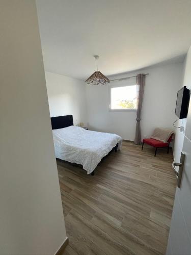 a bedroom with a bed and a television and a window at Chez Tristan in Plouguerneau