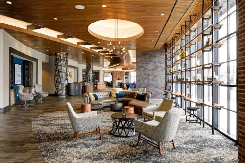 a lobby with couches and chairs in a building at Archer Hotel Boston/Burlington in Burlington