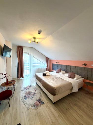 a bedroom with a large bed and a table at Almir Bran in Bran