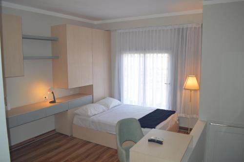 ein kleines Schlafzimmer mit einem Bett, einem Tisch und einem Fenster in der Unterkunft A Residence - Superior One Bedroom Aparthotel in Sharm El Sheikh