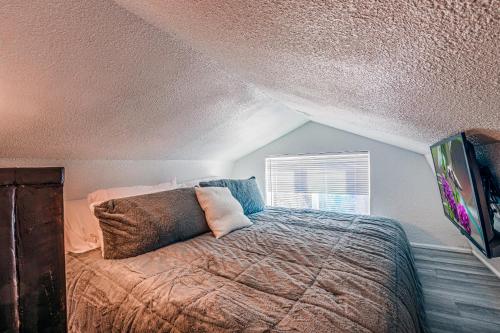 a bedroom with a bed with a comforter and a window at Tiny Home with a Huge View in Ruidoso