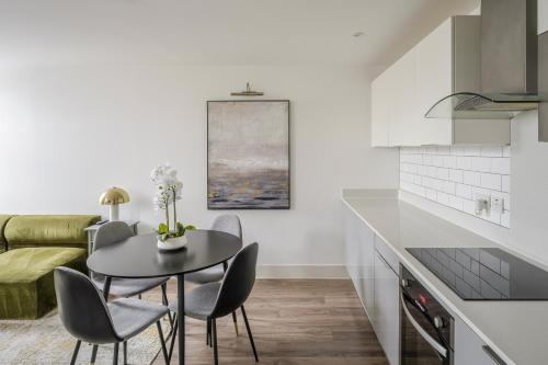 a kitchen and dining room with a table and chairs at Luxurious 2 Bedroom Apartment with Free Parking, Sky TV, Sports, Movies & Netflix in Chelmsford
