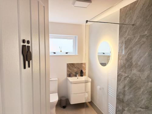 a bathroom with a sink and a toilet and a window at 2 Bedroom City Centre Apartment By Travel Lets Short Term Rental Agency Derry With Free WiFi in Derry Londonderry