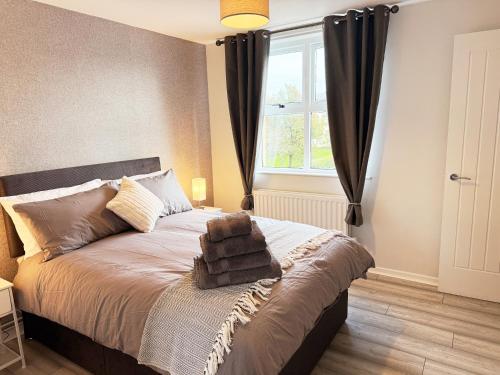 a bedroom with a large bed with a window at 2 Bedroom City Centre Apartment By Travel Lets Short Term Rental Agency Derry With Free WiFi in Derry Londonderry