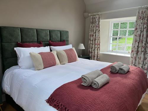 Cosy cottage for two in the highlands في Fortingall: غرفة نوم بها سرير كبير مع مناشف عليه